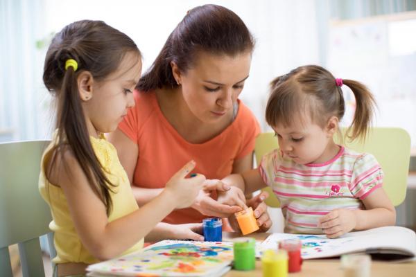 Image représentant une animatrice s'occupant de deux petites filles 