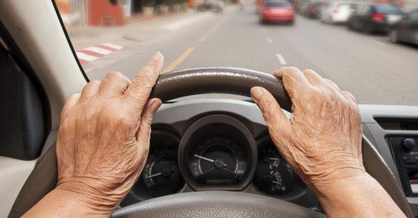 photo de mains d'une personne sénior sur un volant de voiture